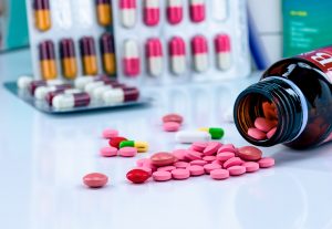 Tablets,Pills,Spread,Out,Of,Amber,Glass,Drug,Bottle,On