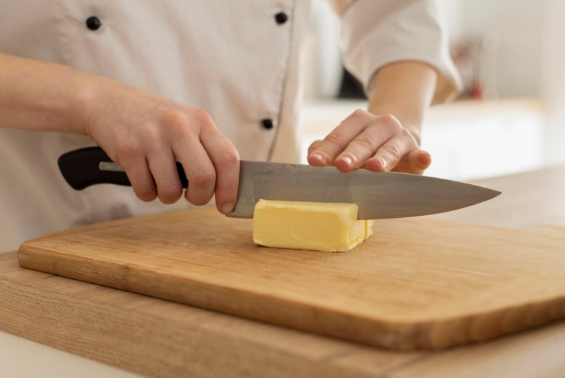 close-up-hands-cutting-butter-1758797659-821x550