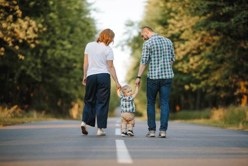 parents-holding-their-little-son-are-walking-road-1758529554-821x550