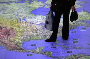 Young person contemplating a large map of North and Central America