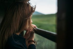 close-up-woman-looking-though-train-window-1760942570-821x550